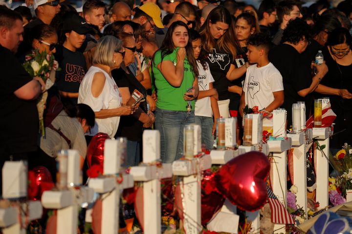 People visit a makeshift memorial at the scene of a mass shooting at a shopping complex, Tuesday, Aug. 6, 2019, in El Paso.