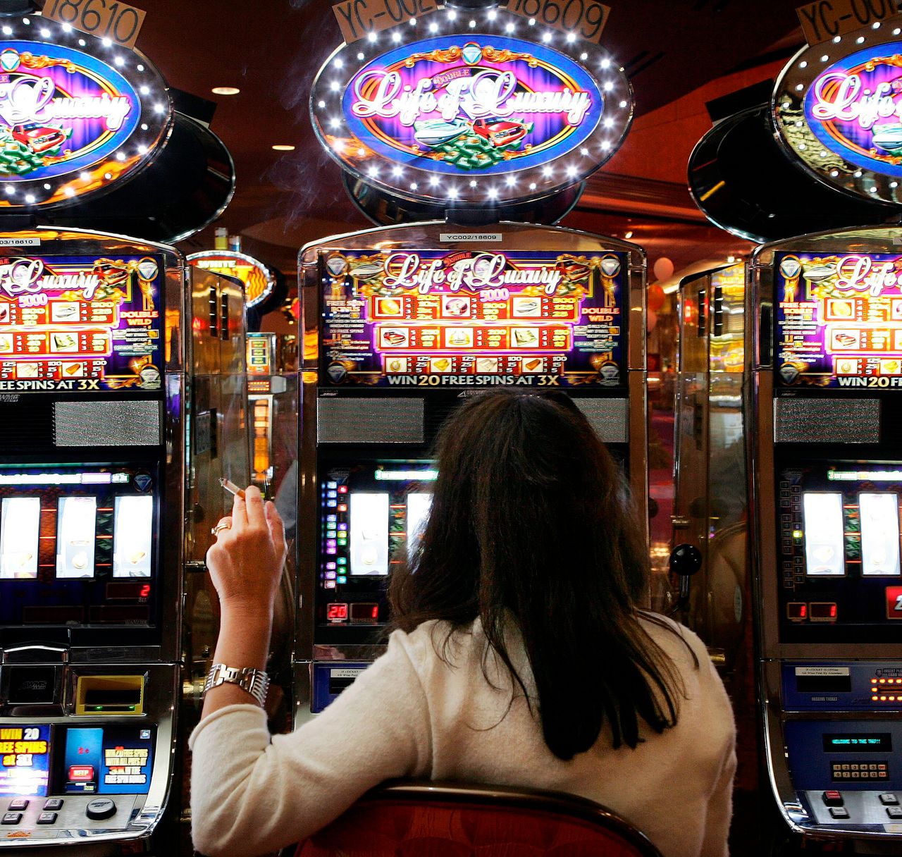 A woman smokes while playing slots at the former Trump Taj Mahal in Atlantic City in 2007. The City Council barred smoking the following year but quickly reversed the ban. Today casinos are allowed to have smoking on 25% of the game floor.