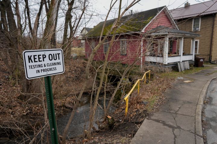 A sign that says "Keep Out: Testing & Cleaning in Progress" is posted near a portion of Sulphur Run Creek that flows under homes in East Palestine, Ohio, on Jan. 30, 2024.