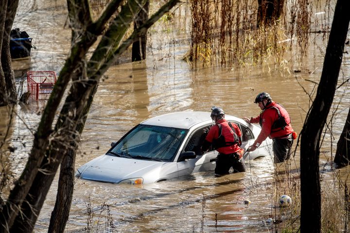 Search and rescue workers investigate a car surrounded by floodwater as heavy rains caused the Guadalupe River to swell, on Feb. 4, 2024, in San Jose, Calif. The vehicle was uninhabited.