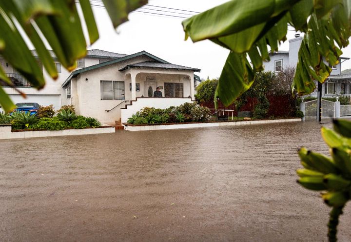 A resident watches as floodwaters rise during a rainstorm, on Feb. 4, 2024, in Santa Barbara, Calif.