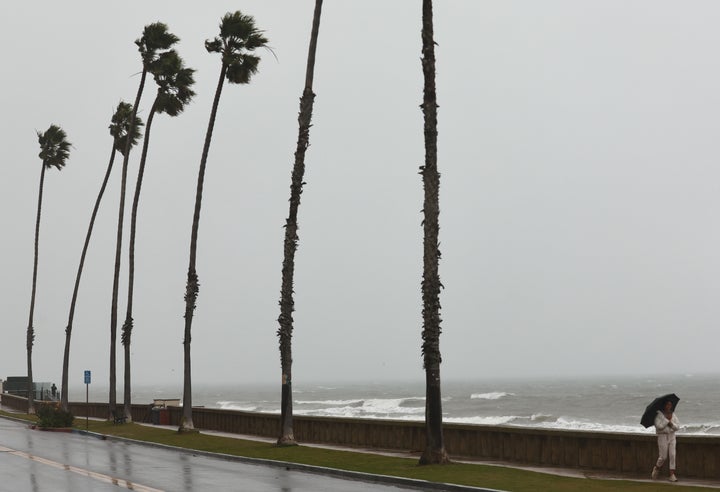 A person walks in the rain as a powerful long-duration atmospheric river storm, the second in less than a week, impacts California on February 4, 2024 in Santa Barbara, California. The storm is delivering potential for widespread flooding, landslides and power outages while dropping heavy rain and snow across the region.