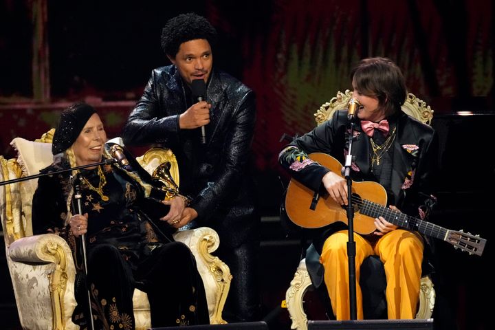 Η θρυλική Τζόνι Μίτσελ, ο οικοδεσπότης βραδιάς Τρέβορ Νόα και η Μπράντι Καρλάιλ, στη σκηνή των Grammy Awards. (AP Photo/Chris Pizzello)