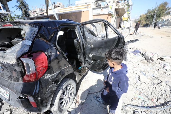 A Palestinian child looks at the damaged car in which 6-year-old Hind Rajab and members of her family died.