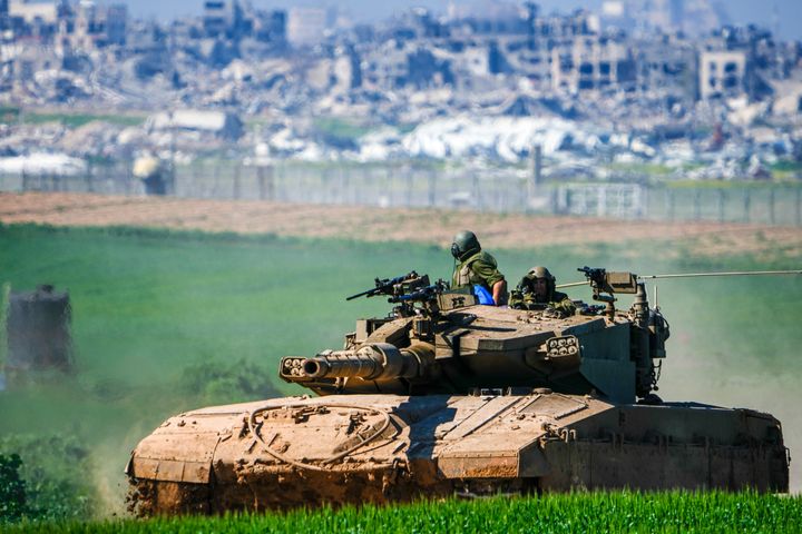 Israeli soldiers drive a tank on the border with the Gaza Strip, as seen in southern Israel, Sunday, Feb. 11, 2024. The army is battling Palestinian militants across Gaza in the war ignited by Hamas' Oct. 7 attack into Israel. (AP Photo/Ariel Schalit)