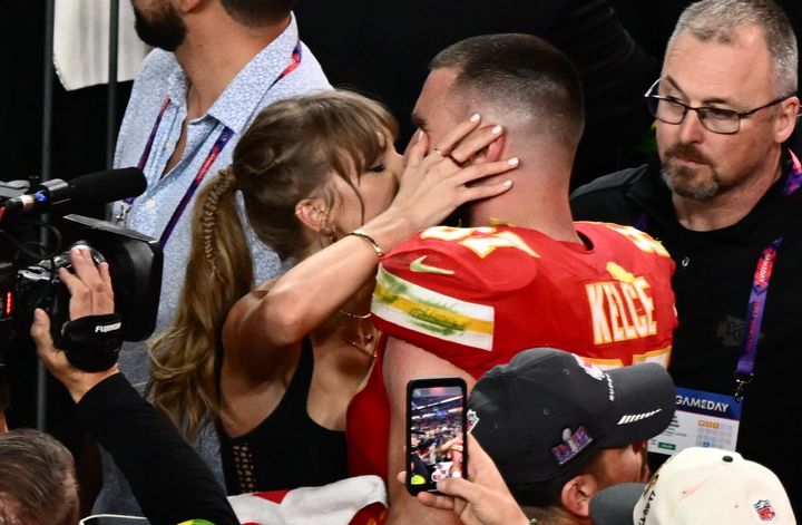 Taylor Swift holds Travis Kelce tight as she kisses him after his big Super Bowl win.