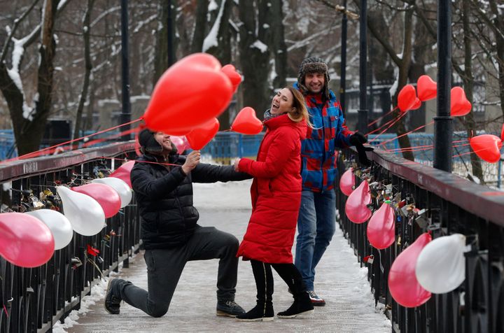 Ενας άντρας γονατίζει μπροστά από ένα κορίτσι στην γέφυρα της αγάπης στο Κίεβο της Ουκρανίας στις 14 Φεβρουαρίου του 2018.