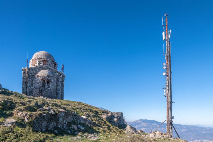 Φωτογραφία ενός πύργου εκπομπής και μιας ελληνικής ορθόδοξης εκκλησίας στο βουνό της Πεντέλης στα βόρεια της Αθήνας, στην Ελλάδα.