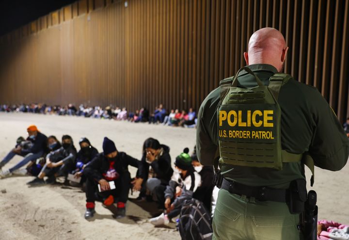 Un agente de la Patrulla Fronteriza de Estados Unidos en Yuma, Arizona, revisa los pasaportes de los migrantes después de que cruzaron la frontera con México el 18 de mayo de 2022.