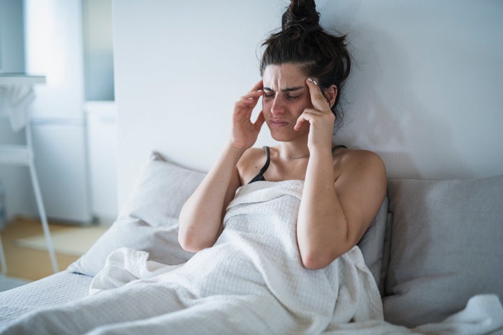 Young woman having a headache and holding her head in her hands.