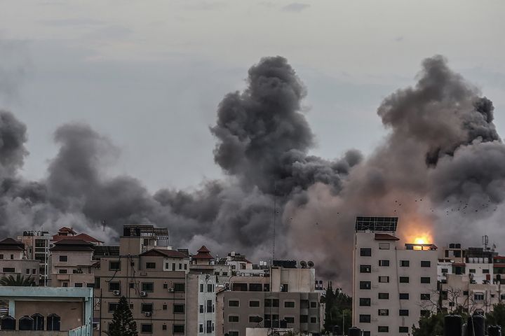 イスラエル軍の攻撃を受けて煙が上がる北部ガザ市の建物（2023年10月9日）