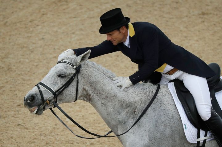 Shane Rose, of Australia, rubs Cp Qualified after competing in the equestrian eventing dressage competition at the 2016 Summer Olympics in Rio de Janeiro, Brazil, Sunday, Aug. 7, 2016. (AP Photo/John Locher)