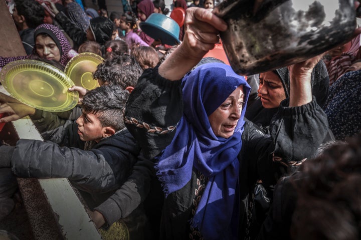 Displaced Palestinians gather to receive food at a government school in Rafah in the southern Gaza Strip on February 19, 2024, amid the ongoing battles between Israel and the militant group Hamas. 