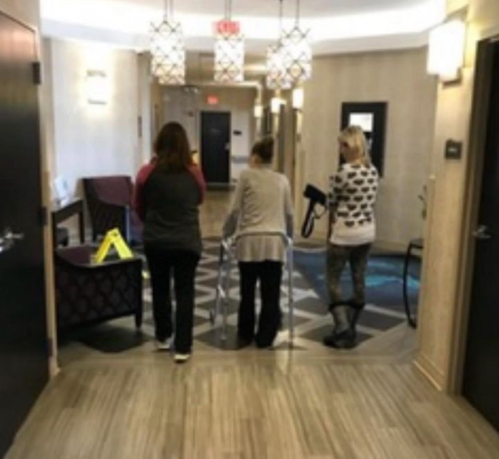 The author (right) and her sister Kathleen (left) take one of their final walks with their sister Kim (center) around the halls of the hospice center days before Kim passed away.