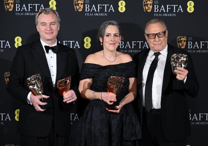 (左から)英国アカデミー賞で作品賞を受賞した映画『オッペンハイマー』のクリストファー・ノーラン監督、プロデューサーのエマ・トーマスさんとチャールズ・ローヴェンさん(2024年2月18日)