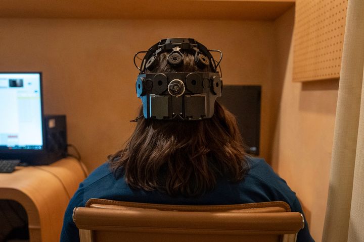 Η Emily Hollenbeck, ασθενής σε θεραπεία βαθιάς εγκεφαλικής διέγερσης, επιδεικνύει μια συσκευή EEG που καταγράφει την εγκεφαλική δραστηριότητα καθώς αντιδρά σε σύντομα βίντεο στο "Q-Lab" του Mount Sinai στη Νέα Υόρκη στις 20 Δεκεμβρίου 2023.
