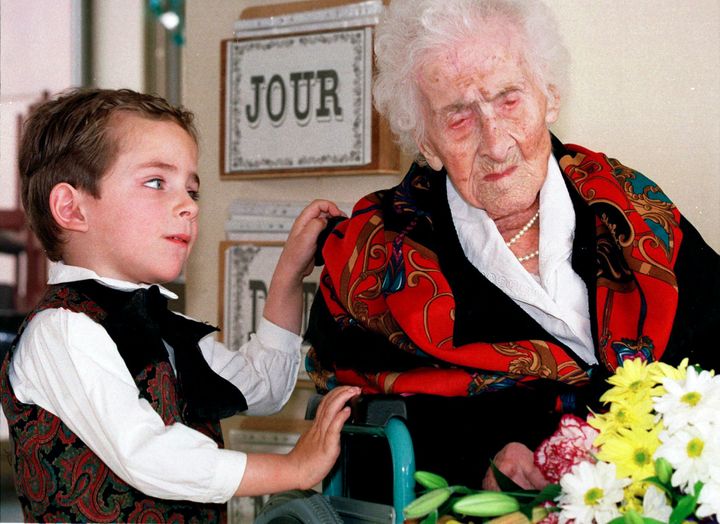 Ενας πεντάχρονος νεαρός έχει μόλις προσφέρει λουλούδια στην Ζαν Καλμάν τον Φεβρουάριο του 1997 σ' αυτή τη φωτογραφία αρχείου. Τους χωρίζουν 117 χρόνια. Η Ζαν Καλμάν έφυγε από την ζωή τον Αύγουστο του ίδιου έτους αφού το «κοντέρ» της ζωής της είχε γράψει 122 χρόνια και 164 μέρες - το μακροβιότερο επιβεβαιωμένο πρόσωπο της ιστορίας. 