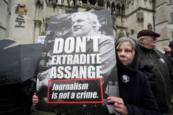 Μία διαδηλώτρια κρατάει ένα πλακάτ έξω από τα Βασιλικά Δικαστήρια στο Λονδίνο, Τετάρτη 21 Φεβρουαρίου 2024. Οι δικηγόροι του Τζούλιαν Ασάνζ στοχεύουν στην τελευταία νομική τους προσπάθεια στο Ηνωμένο Βασίλειο για να εμποδίσουν την έκδοση του ιδρυτή του WikiLeaks στις Ηνωμένες Πολιτείες για να αντιμετωπίσει κατηγορίες για κατασκοπεία.