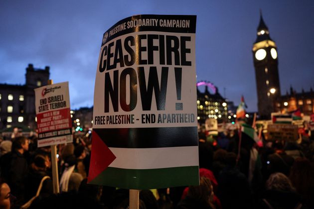 Pro-Palestinian demonstrators wave Palestinian flags and hold placards as they protest in Parliament Square in London on February 21, 2024, during an Opposition Day motion in the the House of Commons calling for an immediate ceasefire in Gaza. (Photo by Adrian DENNIS / AFP) (Photo by ADRIAN DENNIS/AFP via Getty Images)