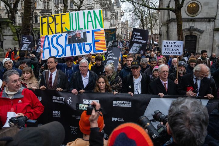 Υποστηρικτές του Τζούλιαν Ασάνζ, συμπεριλαμβανομένης της συζύγου του Στέλλα Ασάνζ, κρατούν πανό καθώς διαδηλώνουν από το Ανώτατο Δικαστήριο προς την Downing Street στις 21 Φεβρουαρίου 2024 στο Λονδίνο, Αγγλία.