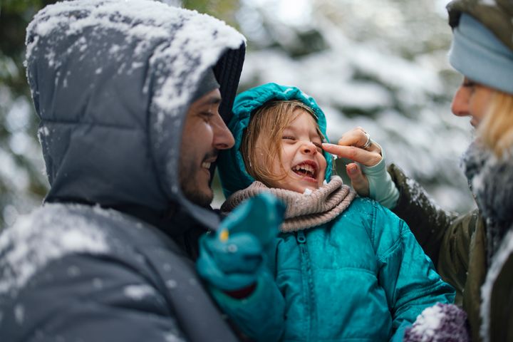 A smiling Caucasian family having fun on the snow.