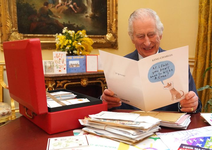 2024年2月21日、ロンドン中心部にあるバッキンガム宮殿で、がんの診断を受けて親しい人々から送られたカードやメッセージを読みながら写真撮影に応じるチャールズ国王