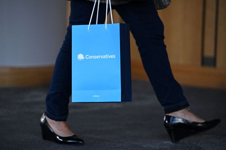 A person holds a bag with the Conservative Party logo on the side.