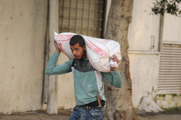 Palestinians, who are unable to meet their basic needs as the Israeli military obstructs humanitarian aid, receive flour from an aid truck that arrived Thursday at Gaza City.