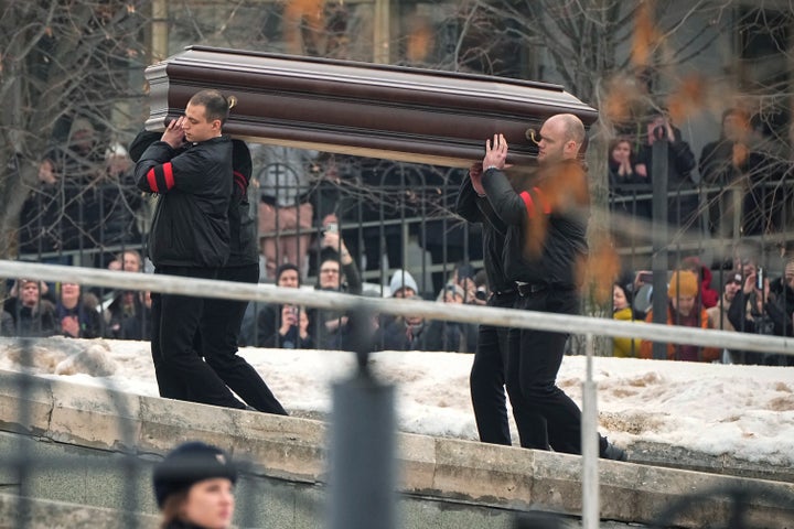 People watch as workers carry the coffin of Russian opposition leader Alexei Navalny to the Church of the Icon of the Mother of God Soothe My Sorrows, in Moscow, Russia, Friday, March 1, 2024. Relatives and supporters of Alexei Navalny are bidding farewell to the opposition leader at a funeral in southeastern Moscow, following a battle with authorities over the release of his body after his still-unexplained death in an Arctic penal colony. (AP Photo)