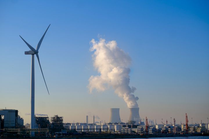 A windmill and the vapor from the Doel Nuclear Power plant are seen from Antwerp Harbor, on February 7, 2023 in Antwerp, Belgium. 