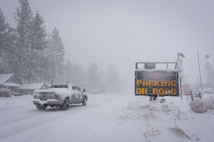 A sign warms motorists of parking restrictions as snow falls Friday, March 1, 2024, in Truckee, California.