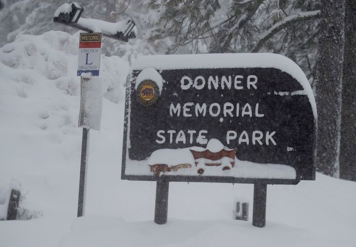 The Donner Memorial State Park sign is covered with snow in Truckee, California, on Friday, March 1, 2024. 