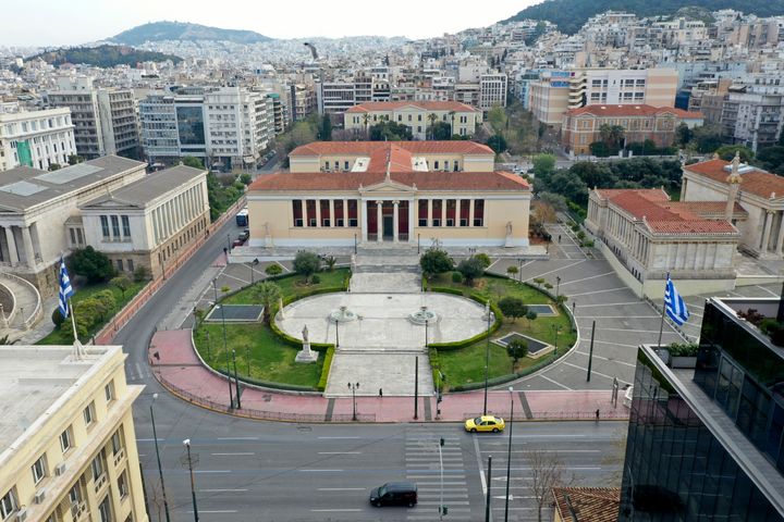 In this Wednesday, April 1, 2020 photo, an aerial view of the Athens University headquarters building and a deserted Panepistimiou street, in Athens. Deserted squares, padlocked parks, empty avenues where cars were once jammed bumper-to-bumper in heavy traffic. The Greek capital, like so many cities across the world, has seen its streets empty as part of a lockdown designed to stem the spread of the new coronavirus. (AP Photo/Thanassis Stavrakis)