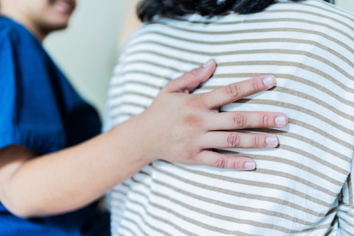 Close-up of a home caregiver consoling senior woman at home