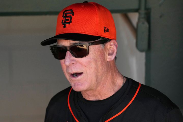 San Francisco Giants manager Bob Melvin talks with coaches in the dugout before a spring training baseball game against the Texas Rangers on Friday, March 1, 2024, in Scottsdale, Arizona.