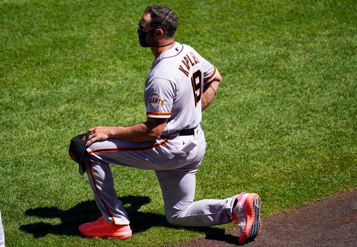 San Francisco Giants manager Gabe Kapler takes a knee while playing the national anthem before a September 2020 game.