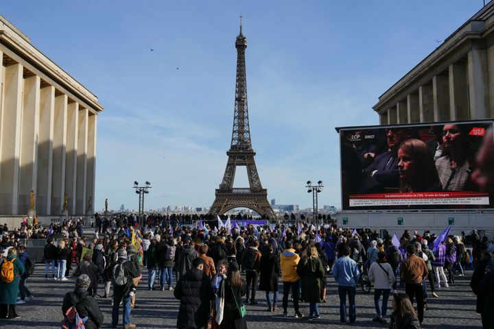People gather near the Eiffel Tower at the Place du Trocadero in Paris on Monday during a broadcasting of the convocation of both houses of parliament to anchor the right of abortion in the country's constitution.