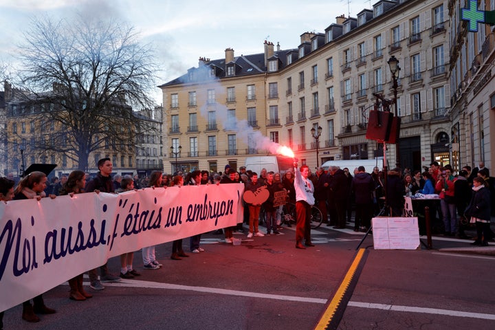 Protesters hold a banner reading 