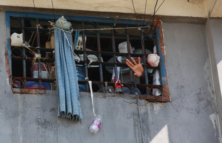 An inmate waves at the National Penitentiary in Port-au-Prince, Haiti, Sunday, March 3, 2024. Hundreds of inmates have fled Haiti's main prison after armed gangs stormed the facility overnight.