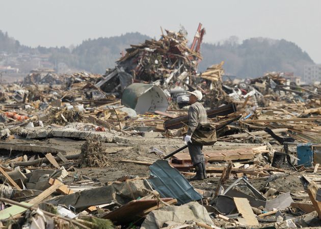 壊滅状態の街を歩く人（2011年3月13日、岩手県陸前高田市）