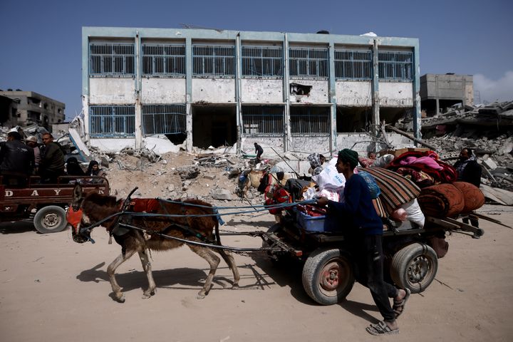 Palestinians carry their belongings after visiting their houses destroyed in the Israeli offensive on Khan Younis, Gaza Strip, on March 6, 2024.