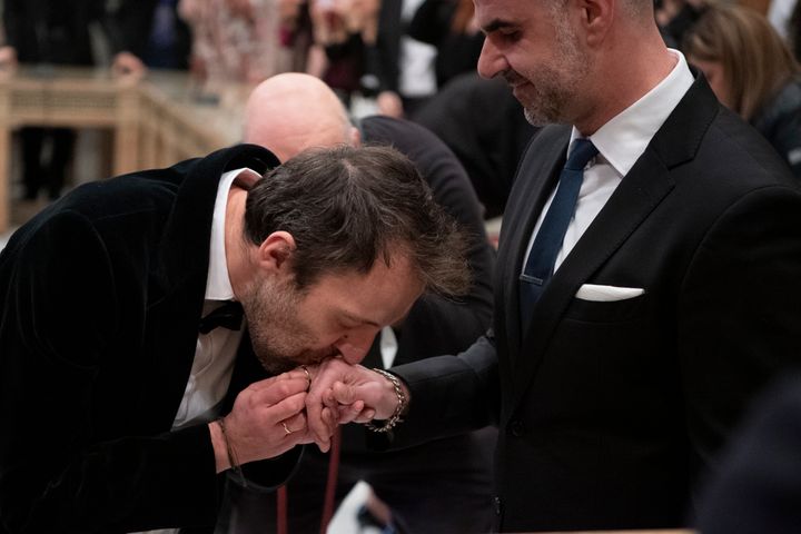 Ο Έλληνας συγγραφέας Πέτρος Χατζόπουλος, ο οποίος χρησιμοποιεί το ψευδώνυμο Auguste Corteau, φιλά το χέρι του συζύγου του, δικηγόρου Αναστάσιου Σαμουηλίδη, κατά τη διάρκεια του γάμου τους στο Δημαρχείο Αθηνών, την Πέμπτη 7 Μαρτίου 2024. (AP Photo/Michael Varaklas)