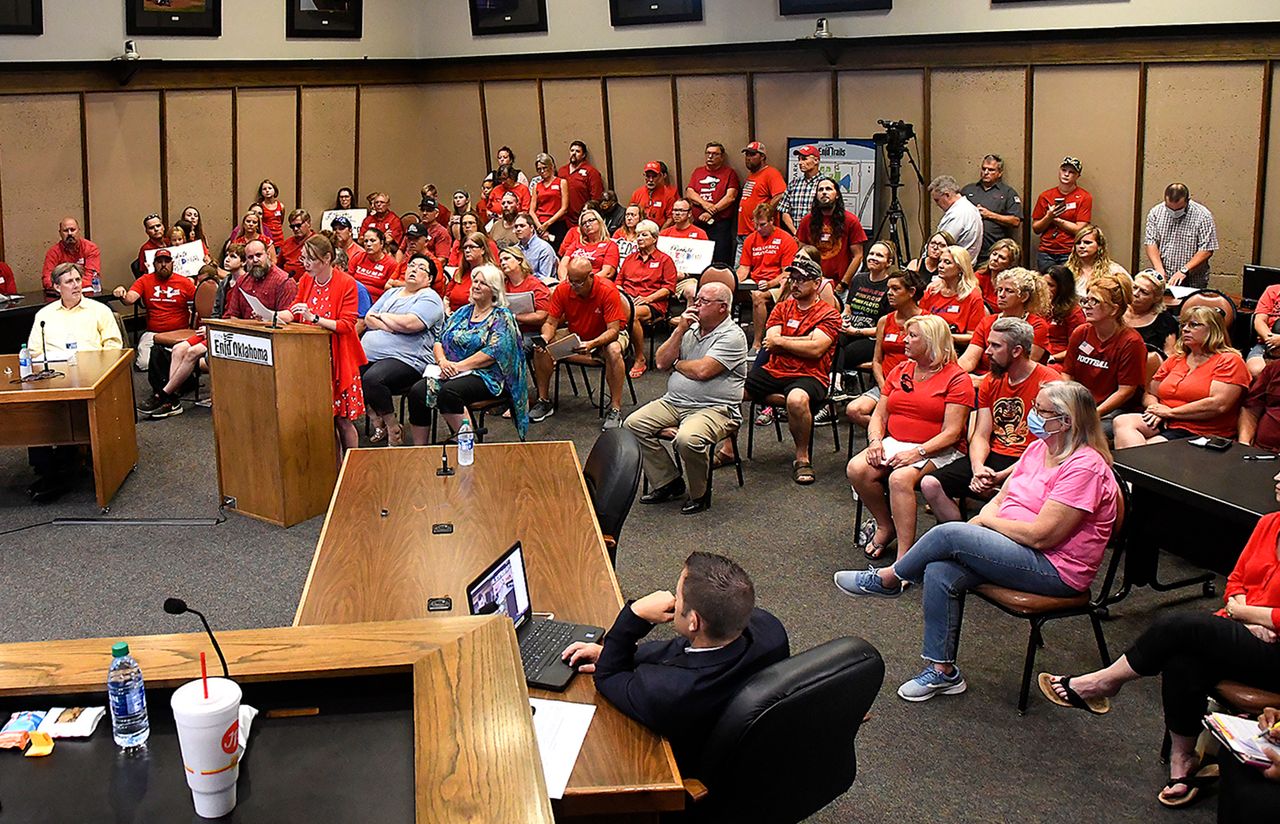 Protesters wear red shirts inside the City Commission chambers in Enid, Okla., during a meeting on whether or not to make wearing a mask mandatory during the coronavirus pandemic, Wednesday, July 15, 2020. 