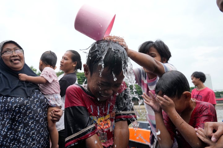 People bathe in the Cisadane River ahead of the holy fasting month of Ramadan in Tangerang, Indonesia, Sunday, March 10, 2024. Muslims followed local tradition to wash in the river to symbolically cleanse their soul prior to entering the holiest month in Islamic calendar.