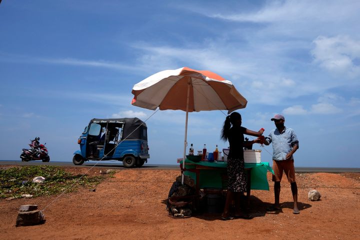 ΑΡΧΕΙΟ - Ένας άνδρας αγοράζει ένα δροσερό ποτό από έναν πωλητή στην άκρη του δρόμου μια ηλιόλουστη μέρα στο Mahawewa, ένα χωριό βόρεια του Κολόμπο της Σρι Λάνκα, 29 Φεβρουαρίου 2024. Η Γη έχει ξεπεράσει τα παγκόσμια ρεκόρ θερμότητας τον Φεβρουάριο, σύμφωνα με την Υπηρεσία για το Κλίμα της Ευρωπαϊκής Ένωσης Κοπέρνικος. (AP Photo/Eranga Jayawardena, File)