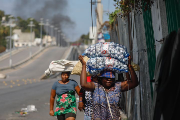 Street vendors run during clashes between police and gangs in Port-au-Prince, Haiti, on Wednesday. Unrelenting gang attacks in Haiti have paralyzed the country and left it with dwindling supplies of basic goods.