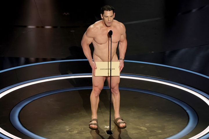 Looking like he has no costume at all, John Cena presents best costume design at the Oscars. 