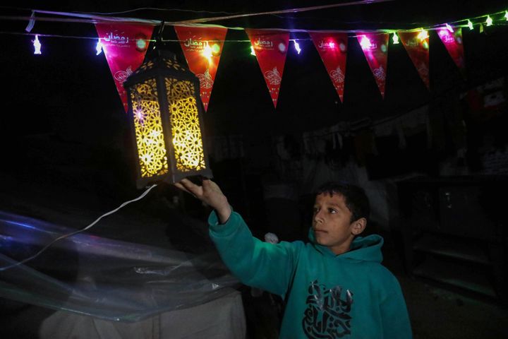 Displaced Palestinians decorate their tent in preparation for the holy month of Ramadan on March 10, 2024, in Rafah, Gaza. 