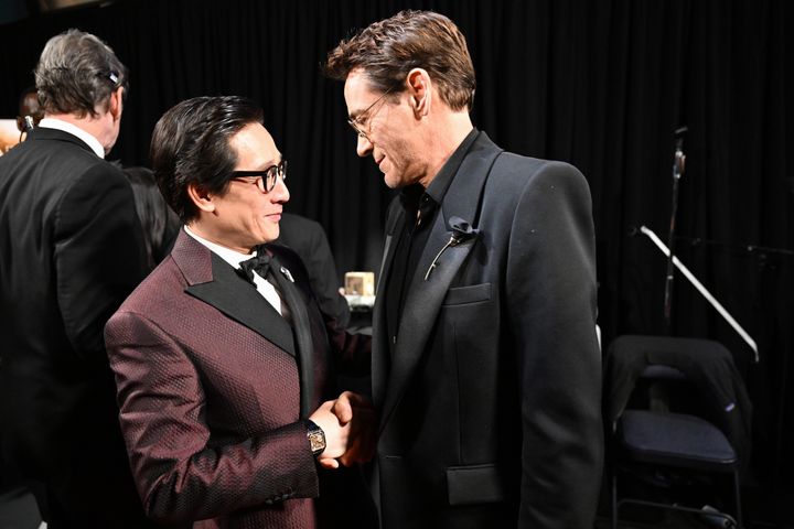 Downey and Quan chat and shake hands in the Oscars’ press room after Downey’s win.