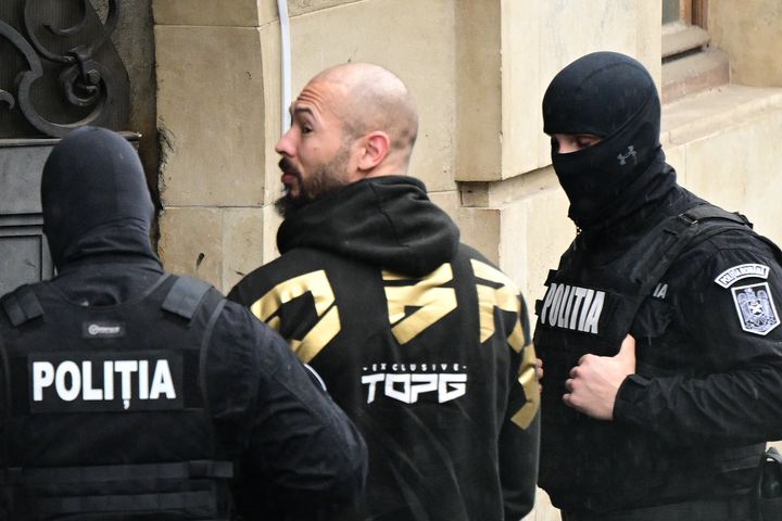 Andrew Tate (C) is led by police officers into the Court of Appeal building in Bucharest, Romania on March 12, 2024, following his and his brother's arrest over UK sex offence charges. 